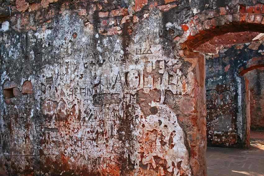 Mur de pierre rouge avec peinture blanche écaillée et dégradée par l'usure Mur de pierre rouge avec peinture blanche écaillée et dégradée par l'usure
