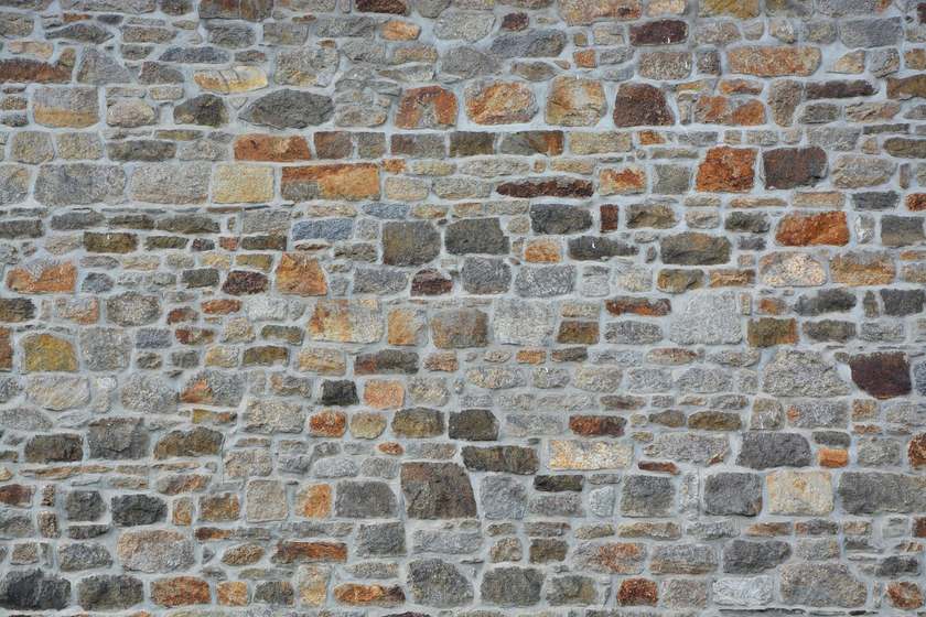 Mur construit avec des pierres de différentes tailles et couleurs, sans mortier apparent Mur construit avec des pierres de différentes tailles et couleurs, sans mortier apparent