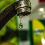 Une goutte d'eau tombe du robinet rouillé dans une cuisine