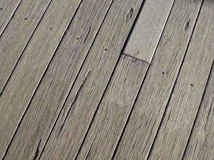 Plancher en bois gris avec une planche plus claire au centre