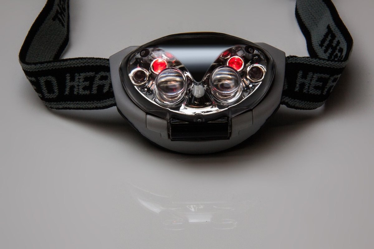 Casque de sécurité avec phares et réflecteurs, bandeau noir, sur fond neutre