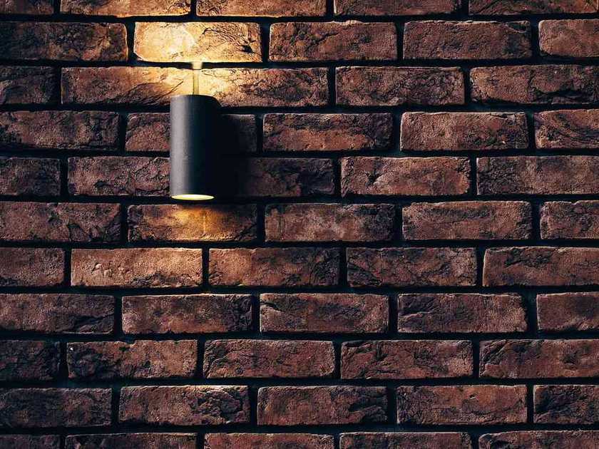 Lampe murale noir sur mur de briques, lumière chaude Lampe murale noir sur mur de briques, lumière chaude