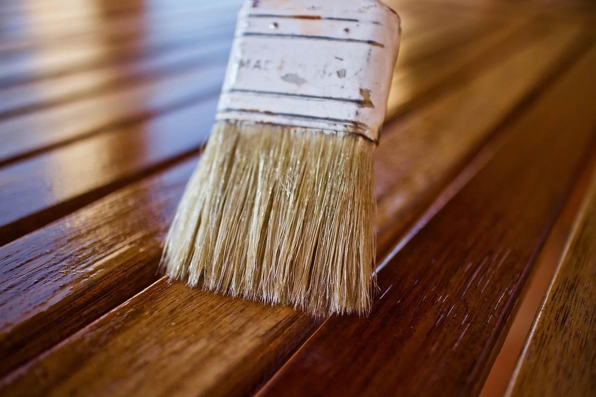 Pinceau appliquant une finition protectrice sur des lames de parquet en chêne verni Pinceau appliquant une finition protectrice sur des lames de parquet en chêne verni